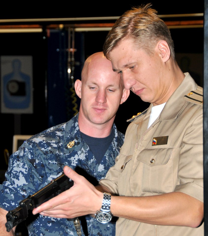 US Navy 090925-N-8848T-728 Chief Fire Controlman Randall Shilton and Russian navy Cmdr. Igor Elkin look over a specially designed 9mm pistol in the Simulated Arms Marksmanship Trainer at Recruit Training Command