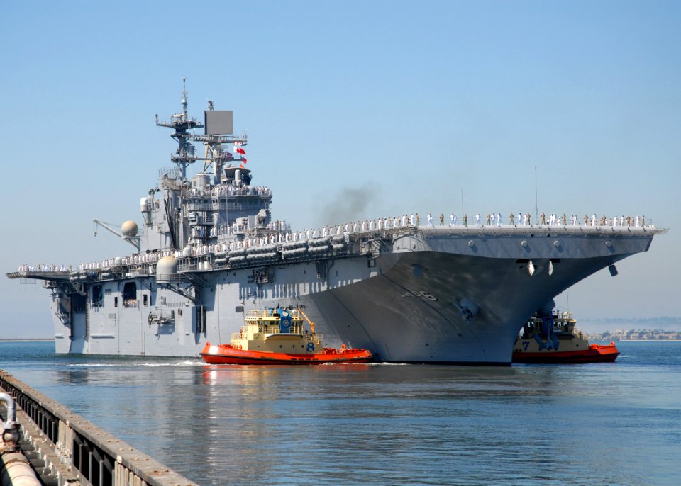 US Navy 090924-N-8283S-204 Tug boats guide the amphibious assault ship USS Bonhomme Richard (LHD 6) as she turns into San Diego Bay