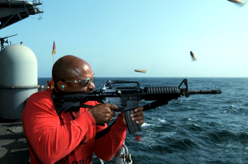 US Navy 090925-N-3038W-330 Chief Gunner's Mate Anthony Chatman fires an M-4 service rifle during a live-fire exercise on the fantail of the aircraft carrier USS Nimitz (CVN 68)