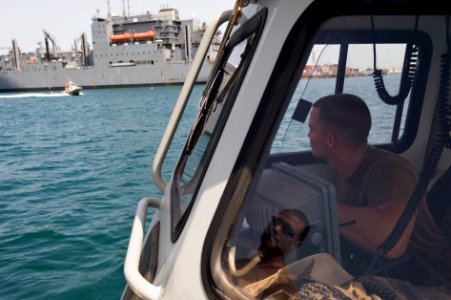 US Navy 090929-N-6725B-071 Master-at-Arms 3rd Class Sydney Swift watches an incoming U.S. Navy eight meter rigged hull inflatable boat as it speeds past the Military Sealift Command dry cargo-ammunition ship USNS Amelia Earhart photo