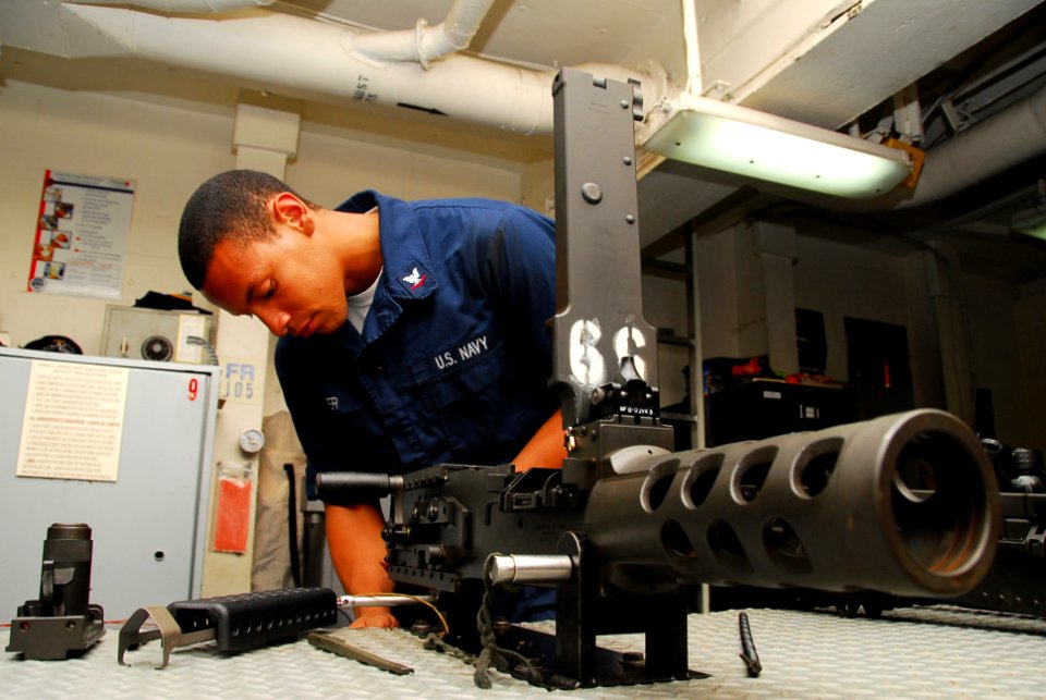 US Navy 090927-N-2918M-041 Gunner's Mate 3rd Class Chino Cooper disassembles and cleans a .50 caliber machine gun in the armory on board the aircraft carrier USS Nimitz (CVN 68)