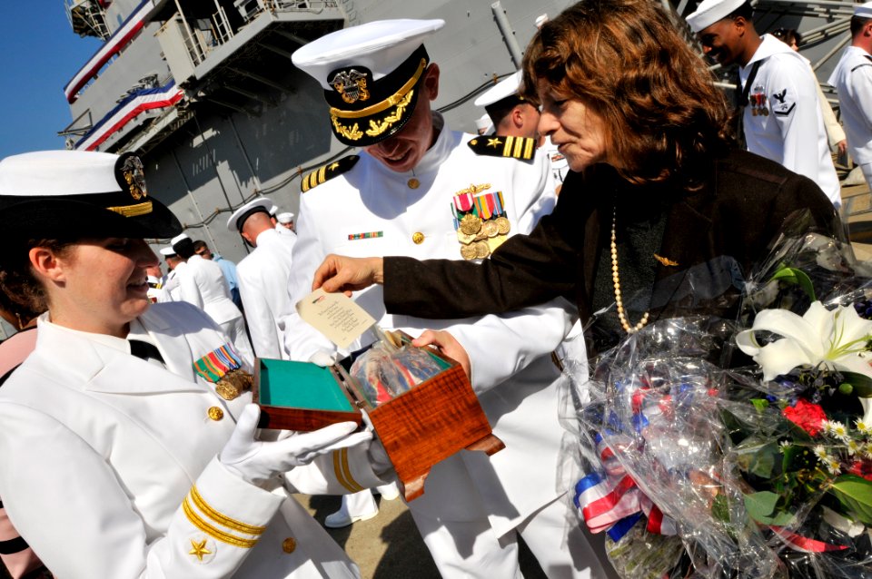 US Navy 090930-N-3595W-442 Katherine Coombs, right, granddaughter of the original sponsor of the amphibious transport dock ship USS Nashville (LPD 13) shows memorabilia from the ship's christening in 1967
