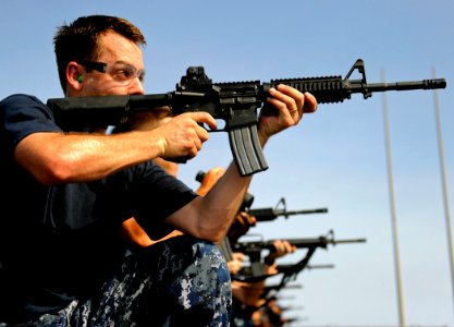 US Navy 090930-N-5345W-030 Information Systems Technician 1st Class Mark Mercier aims his M-4 assault rifle downrange as he participates in a weapons qualification exercise on the flight deck of the amphibious dock landing ship