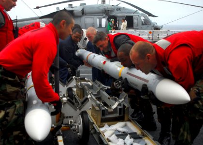 US Navy 090926-N-8607R-051 Aviation ordnancemen move missiles from the flight deck to the aft elevator aboard the amphibious assault ship USS Bonhomme Richard (LHD 6)