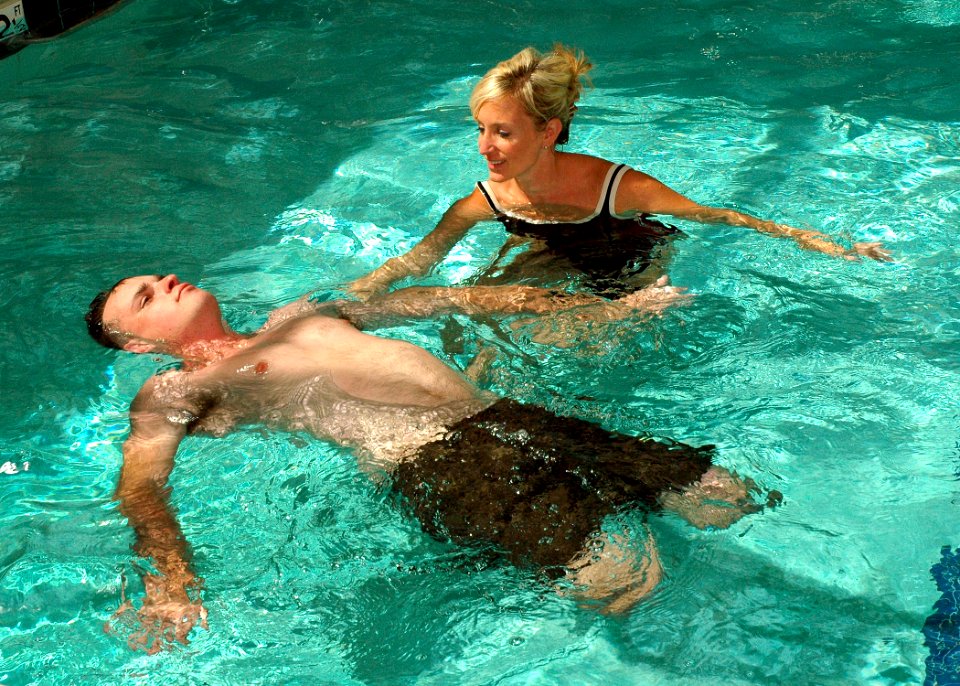 US Navy 091001-N-6326B-080 Lynn A. Boulanger, a Naval Medical Center San Diego occupational therapist, assists Marine Corps Staff Sgt. Jesse A. Cottle, a bilateral amputee, while he practices swimming during endurance training