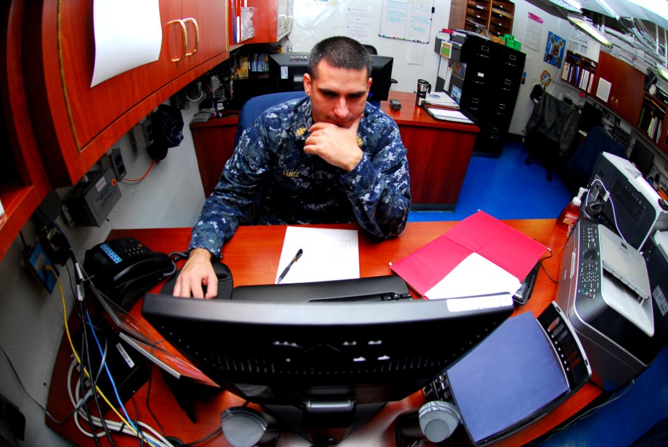 US Navy 090927-N-2918M-031 Chief Yeoman Brett Lentz, Flag Administration Officer, checks the status of Carrier Strike Group (CVW) 11 personnel in the Flag Admin office aboard the aircraft carrier USS Nimitz (CVN 68)