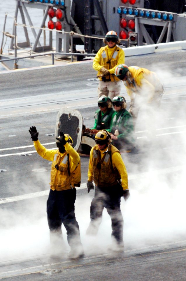 US Navy 090927-N-4053P-015 An aviation boatswain mate signals an aircraft to align with the catapult on the flight deck of the aircraft carrier USS Nimitz (CVN 68)