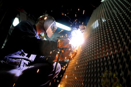 US Navy 090928-N-3830J-091 Hull Maintenance Technician 2nd Class Paris Luh welds a broken piece of the man overboard locker aboard the amphibious command ship USS Blue Ridge (LCC 19) while underway on a scheduled deployment
