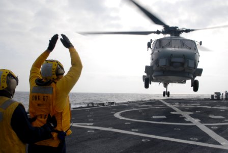 US Navy 090930-N-1688B-423 oatswain's Mate 2nd Class Brandon Carney, from Stratford, N.J., directs an SH-60 Sea Hawk helicopter assigned to the Vipers of Helicopter Anti-Submarine Squadron Light (HSL) 48