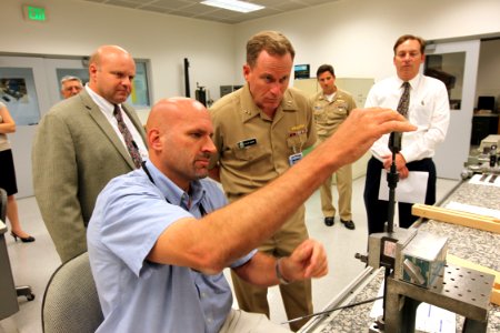 US Navy 090929-N-8863V-008 Engineering Technician Joseph Zinky, center, explains his work with a .50-caliber barrel erosion gage to Rear Adm. Kevin Quinn, commander, Naval Surface Force Atlantic