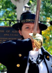 US Navy 091004-N-2893B-001 Aviation Electrician's Mate 3rd Class Tenika Fugate, assigned to USS Constitution, raises a cutlass during a color guard detail in Old Town during Albuquerque Navy Week