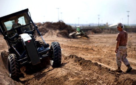 US Navy 090928-N-7526R-340 Equipment Operator 2nd Class Norman Patton, assigned to Navy Mobile Construction Battalion (NMCB) 3, watches over Equipment Operator Constructionman Amber Schmickuses