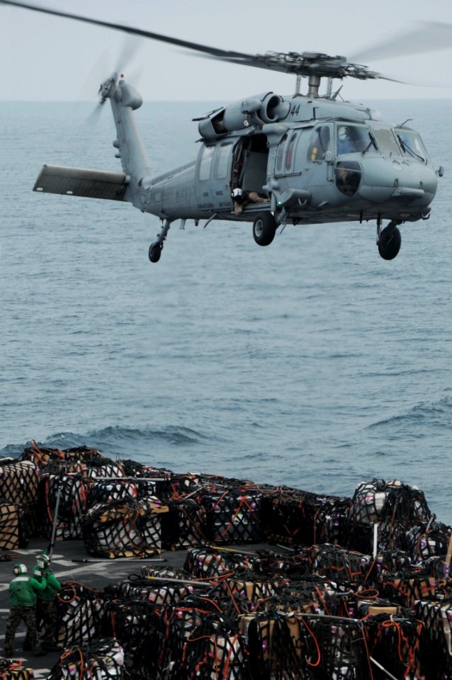 US Navy 091001-N-3038W-233 An MH-60S Sea Hawk helicopter assigned to the Wildcards of Helicopter Sea Combat Squadron (HCS) 23 prepares to lift cargo from the USNS Bridge (T-AOE 10) to the flight deck of the USS Nimitz (CVN 68)