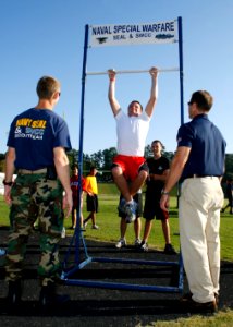 US Navy 091003-N-5366K-118 Capt. Adam Curtis and Cmdr. Brian Casson, assigned to Naval Special Warfare (NSW) Command help to motivate a student during the Navy SEAL Fitness Challenge held at Grimsley High School photo