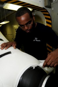 US Navy 090930-N-3038W-070 Aircrew Survival Equipmentman 2nd Class Jamal Barconey tests the seal of a dry suit after making repairs in the paraloft aboard the aircraft carrier USS Nimitz (CVN 68) photo