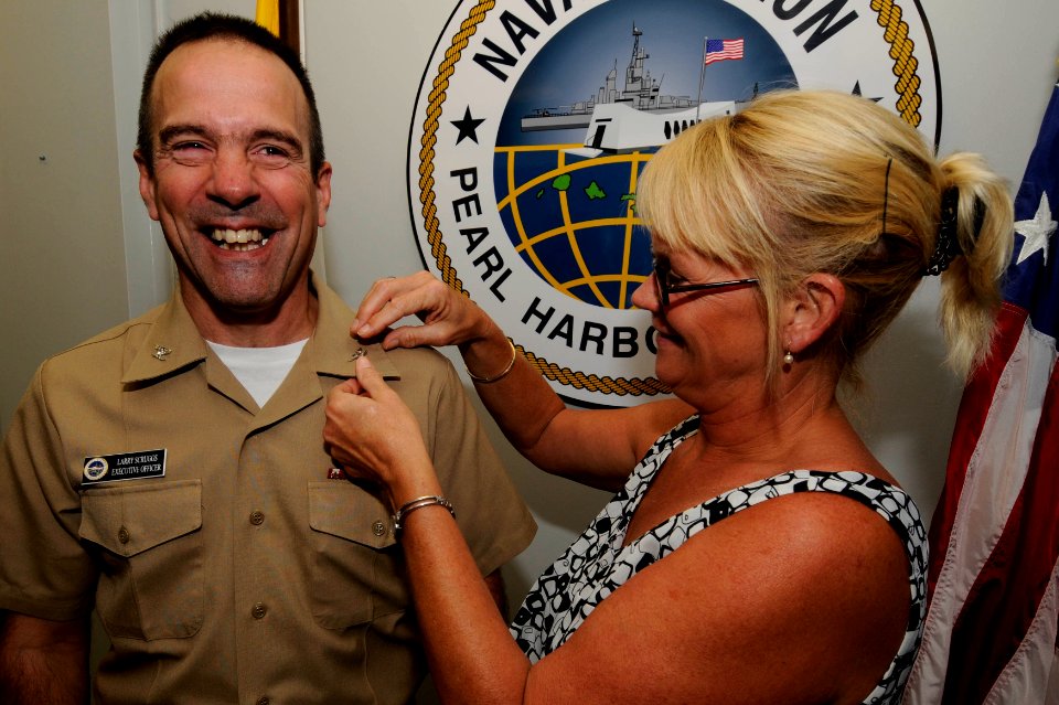 US Navy 091001-N-7498L-028 Capt. Lawrence Scruggs, executive officer of Naval Station Pearl Harbor, has his eagles pinned on his uniform by his wife