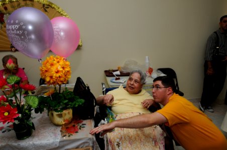 US Navy 091006-N-1906L-369 Hospital Corpsman 2nd Class Jeson Hall, assigned to the amphibious transport dock ship USS Cleveland (LPD 7), looks at birthday party balloons with a resident