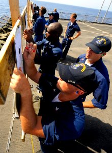 US Navy 090930-N-5345W-074 Firing line coaches grade their shooters' scores during an M-16-M-4 weapons qualifications on the flight deck of the amphibious dock landing ship USS Fort McHenry (LSD 43)