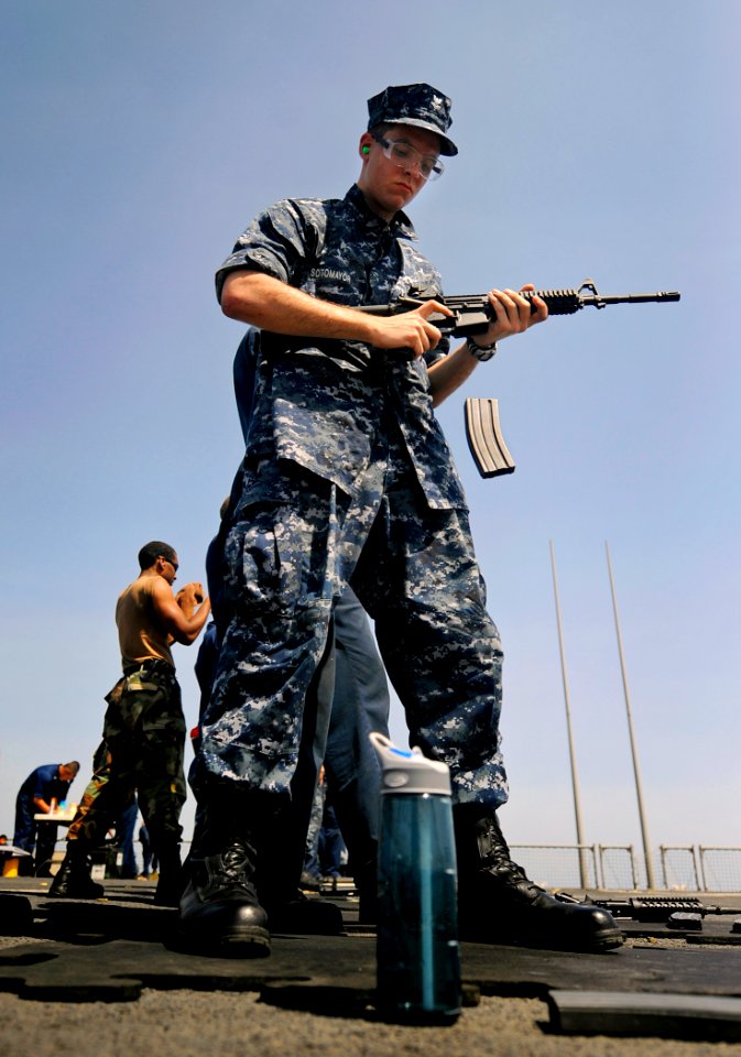 US Navy 090930-N-5345W-305 Operations Specialist 2nd Class Jeremy Sotomayor ejects an empty magazine from his M-4 assault rifle during a weapons qualification exercise on the flight deck of the amphibious dock landing ship USS