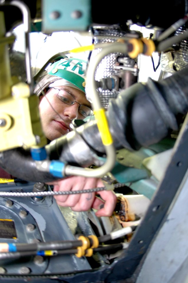 US Navy 091006-N-8960W-006 Aviation Structural Mechanic Airman Wilson Morian performs maintenance on the wing of an F-A-18C Hornet assigned to the Sidewinders of Strike Fighter Squadron (VFA) 86