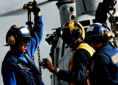 US Navy 091007-N-0807W-095 Landing Signalmen Enlisted Boatswain's Mate Salomon Michel inspects chocks and chains pulled from a U.S. Marine Corps CH-46 Sea Knight helicopter before takeoff