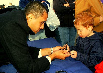 US Navy 091003-N-2888Q-012 Airman Jose Porcayo assigned to USS Constitution, helps a child tie knots at the International Balloon Fiesta. Sailors from USS Constitution wore circa-1813 uniforms and participated in Albuquerque Na photo