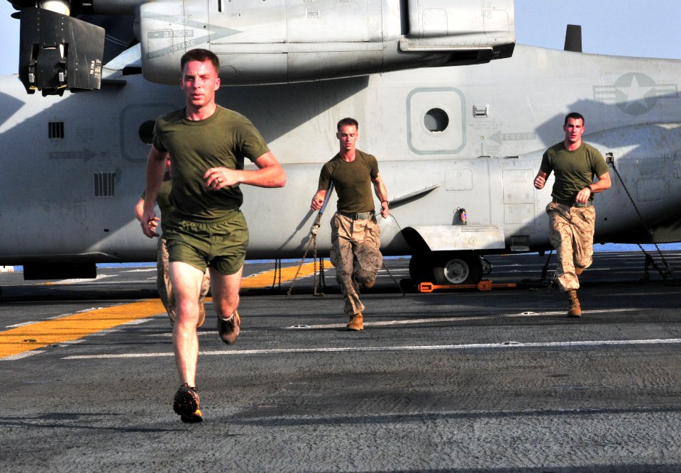 US Navy 091004-N-9740S-006 Marines assigned to the 22nd Marine Expeditionary Unit (22nd MEU) run sprints near an MV-22B Osprey