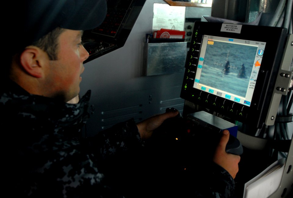 US Navy 091005-N-1688B-039 Fire Controlman 3rd Class Billy Coffelt uses a remote console for the 25-mm gun aboard the guided-missile destroyer USS Cole (DDG 67) during a small boat attack drill
