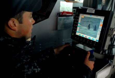 US Navy 091005-N-1688B-039 Fire Controlman 3rd Class Billy Coffelt uses a remote console for the 25-mm gun aboard the guided-missile destroyer USS Cole (DDG 67) during a small boat attack drill
