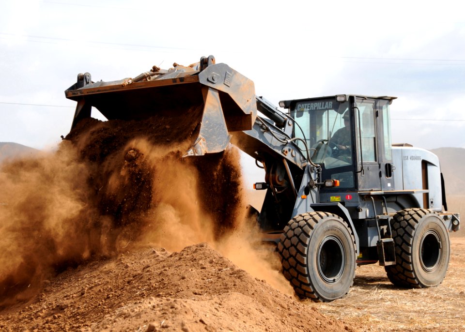 US Navy 091007-N-1424C-159 Seabee assigned to amphibious construction battalion ONE (ACB-1) controls a wheel loader to construct part of the life support area (LSA) for 800 military personnel