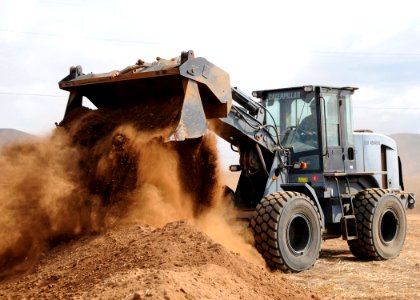 US Navy 091007-N-1424C-159 Seabee assigned to amphibious construction battalion ONE (ACB-1) controls a wheel loader to construct part of the life support area (LSA) for 800 military personnel