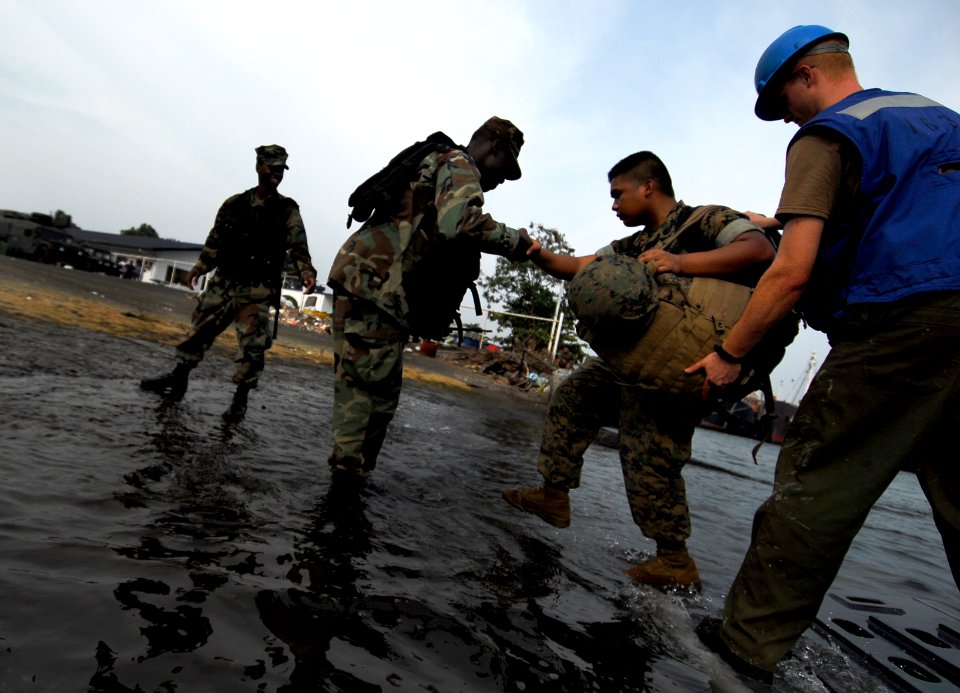 US Navy 091005-N-0807W-530 Sailors assigned to Assault Craft Unit (ACU) 5 and the 31st Marine Expeditionary Unit (31st MEU) disembark from Landing Craft Utility (LCU) 1631 during an equipment and supply offload