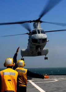 US Navy 091006-N-6692A-034 Sailors signal a Marine Corps CH-46 Sea Knight helicopter aboard the amphibious dock landing ship USS Tortuga (LSD 46) photo