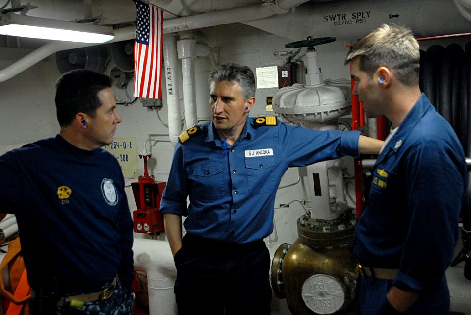 US Navy 091006-N-1688B-359 Royal Navy Commodore Simon Ancona, center, commander of United Kingdom Carrier Strike Group, speaks with Cmdr. Edward Devinney, left, commanding officer of the guided-missile destroyer USS Cole (DDG 6