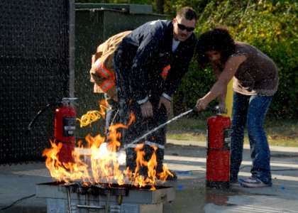 US Navy 091005-N-9860Y-001 Alan Sprouse, a Navy Region Northwest Fire and Emergency Services fire inspector, helps a School Age Care Programs student extinguish a grease fire