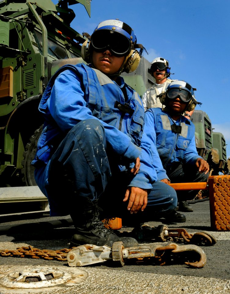 US Navy 091008-N-5345W-017 Seaman John Mendez, left, Boatswain's Mate Seaman Antoinette Smith and Boatswain's Mate 1st Class Jay Collette watch an approaching helicopter from the flight deck of the amphibious dock landing ship