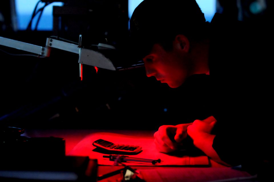 US Navy 091008-N-7478G-085 Quartermaster Seaman Jared Breland checks his calculations for moonrise aboard the amphibious command ship USS Blue Ridge (LCC 19)