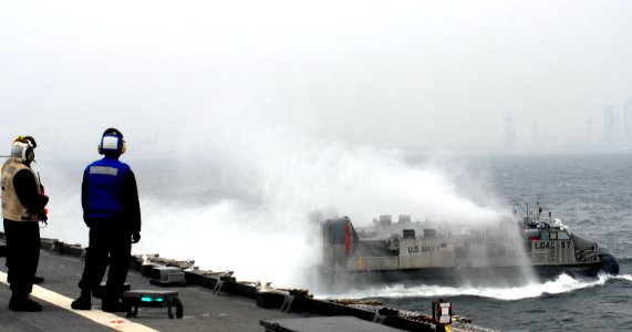 US Navy 091005-N-6692A-063 Sailors assigned to the amphibious dock landing ship USS Tortuga (LSD 46) watch as a landing craft, air cushion (LCAC) from Assault Craft Unit (ACU) 5 launches from the well deck photo