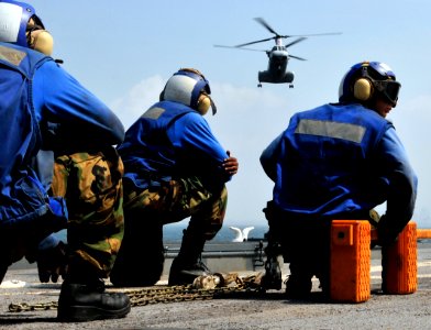 US Navy 091006-N-0807W-102 ailors aboard the amphibious dock landing ship USS Harpers Ferry (LSD 49) prepare to chalk and chain an incoming U.S. Marine Corps CH-46 Sea Knight helicopter photo