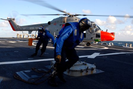 US Navy 091006-N-1688B-427 Sailors remove the chocks and chains from a British Royal Navy Lynx helicopter and clear the flight area aboard the guided-missile destroyer USS Cole (DDG 67)