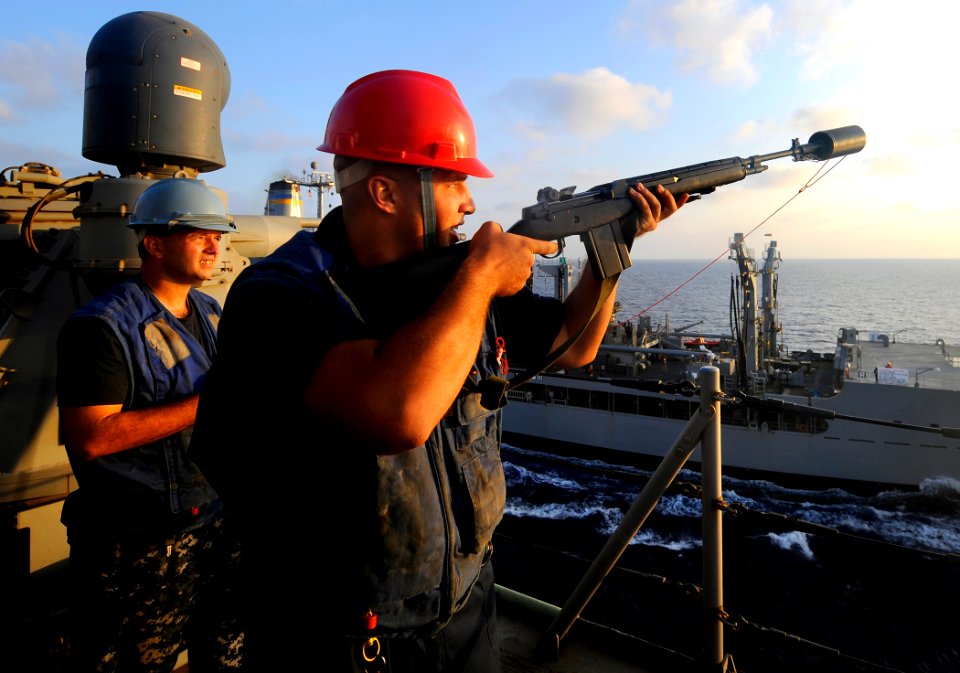 US Navy 091008-N-5345W-189 Gunner's Mate 3rd Class Steven Kowalski prepares to fire a messenger line from the bridge deck of the amphibious dock landing ship USS Fort McHenry (LSD 43)