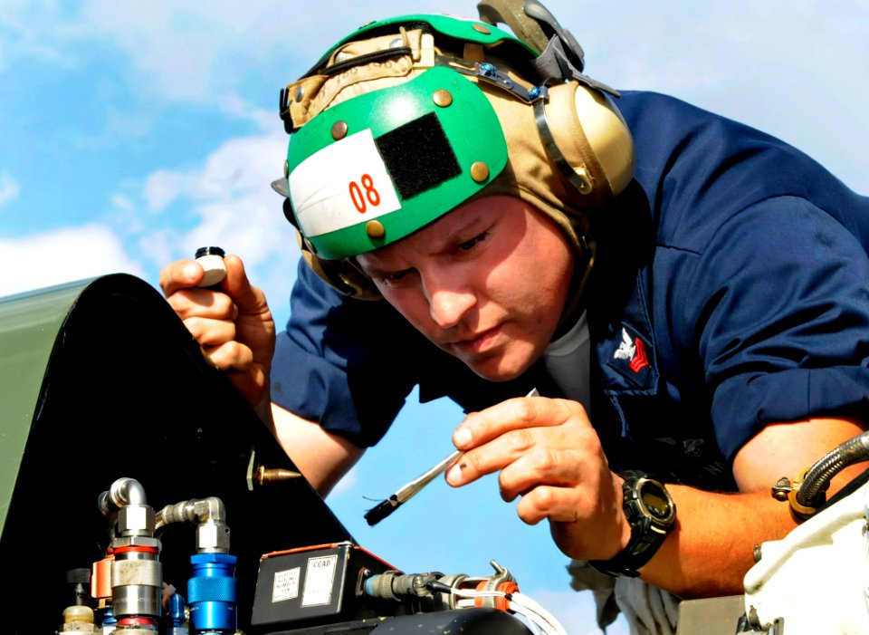US Navy 091007-N-7478G-362 Aviation Structural Mechanic 1st Class Lawrence Smathers, assigned to Light Helicopter Antisubmarine Squadron (HSL) 51, performs preventive maintenance under the top hood of an SH-60F Sea Hawk helicop