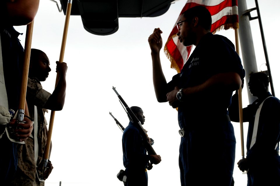 US Navy 091009-N-3830J-128 Yeoman 3rd Class Tremaine Gordon, a Sailor assigned to the 7th Fleet staff, instructs the honor guard on proper handling of flags while aboard the amphibious command ship USS Blue Ridge (LCC 19)