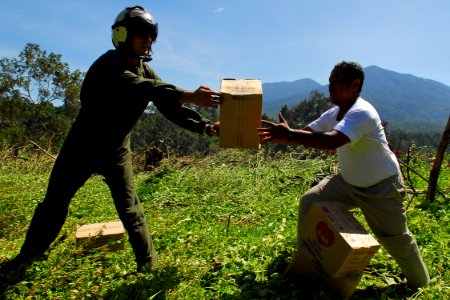 US Navy 091009-N-9123L-091 Marine Staff Sergeant Sean Kayser, a St. Inigoes, Md. native unloads relief supplies to an Indonesian citizen