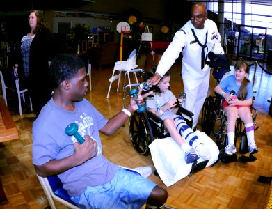 US Navy 091007-N-6220J-012 Operations Specialist 2nd Class Yusef Robertson hands out toys at Shriners Hospital for Children in Greenville during a Caps For Kids event as part of Greenville Navy Week