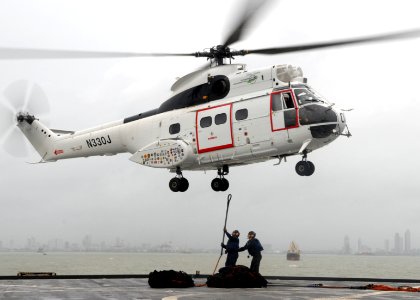 US Navy 091008-N-6692A-078 Seaman Stephen Grande from Cranston, R.I., and Seaman Jeremy Lingle from West Frankfort, Ill., hook up a pendant to a SA-330 Puma helicopter