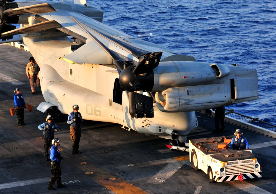 US Navy 091009-N-9740S-018 Sailors assigned to the multi-purpose amphibious assault ship USS Bataan (LHD 5) and embarked Marines from the 22nd Marine Expeditionary Unit (22nd MEU) move an MV-22B Osprey on the ship's flight deck