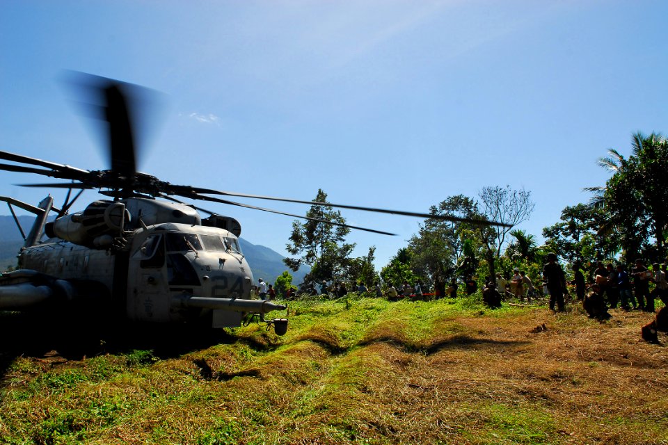 US Navy 091009-N-9123L-105 U.S. Air Force personnel, U.S. Marines, Indonesian Air Force personnel, and Indonesian citizens unload a CH-53E Super Stallion helicopter assigned to the Dragons
