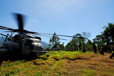 US Navy 091009-N-9123L-105 U.S. Air Force personnel, U.S. Marines, Indonesian Air Force personnel, and Indonesian citizens unload a CH-53E Super Stallion helicopter assigned to the Dragons photo