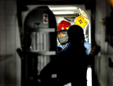 US Navy 091008-N-7280V-109 Culinary Specialist Seaman Chaohua Lin receives a message before establishing a primary fire boundary during a major fuel oil leak drill aboard amphibious command ship USS Blue Ridge (LCC 19)